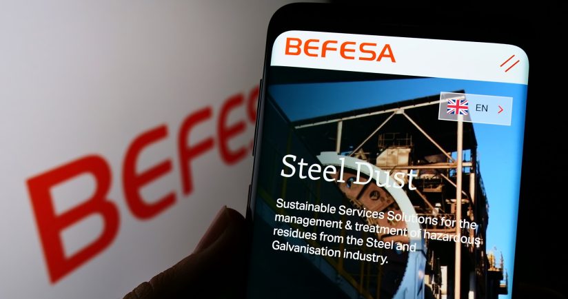 Smartphone-Bildschirm zeigt eine Webseite mit dem Titel "Steel Dust" und einem Industriegebäude.