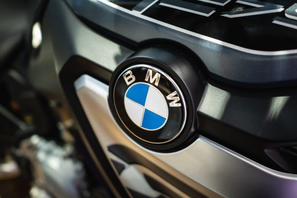 BMW-Logo auf schwarzem Hintergrund an einem Fahrzeug montiert.