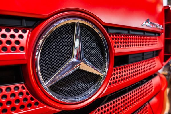 Roter Fahrzeuggrill mit Mercedes-Stern in Nahaufnahme.