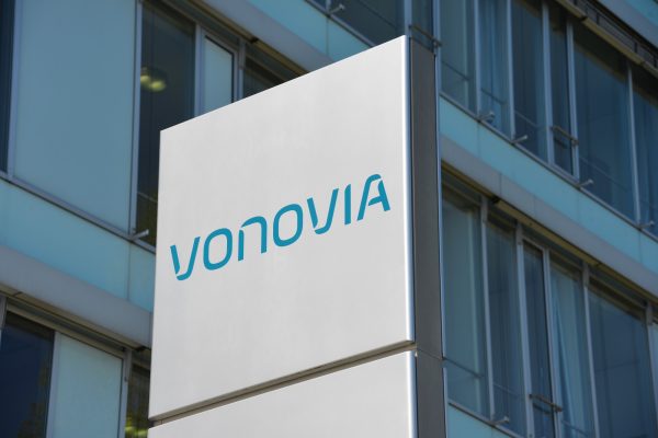 Gebäude mit großem Schild, das blaues Logo und Schriftzug "Vonovia" zeigt. Moderne Glasfassade im Hintergrund.